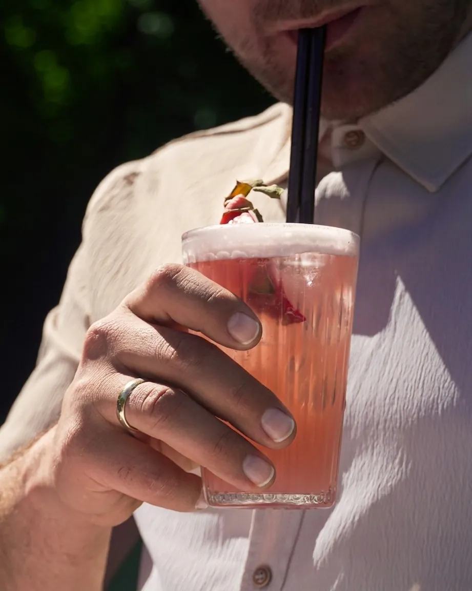 Gast genießt einen rosafarbenen Cocktail