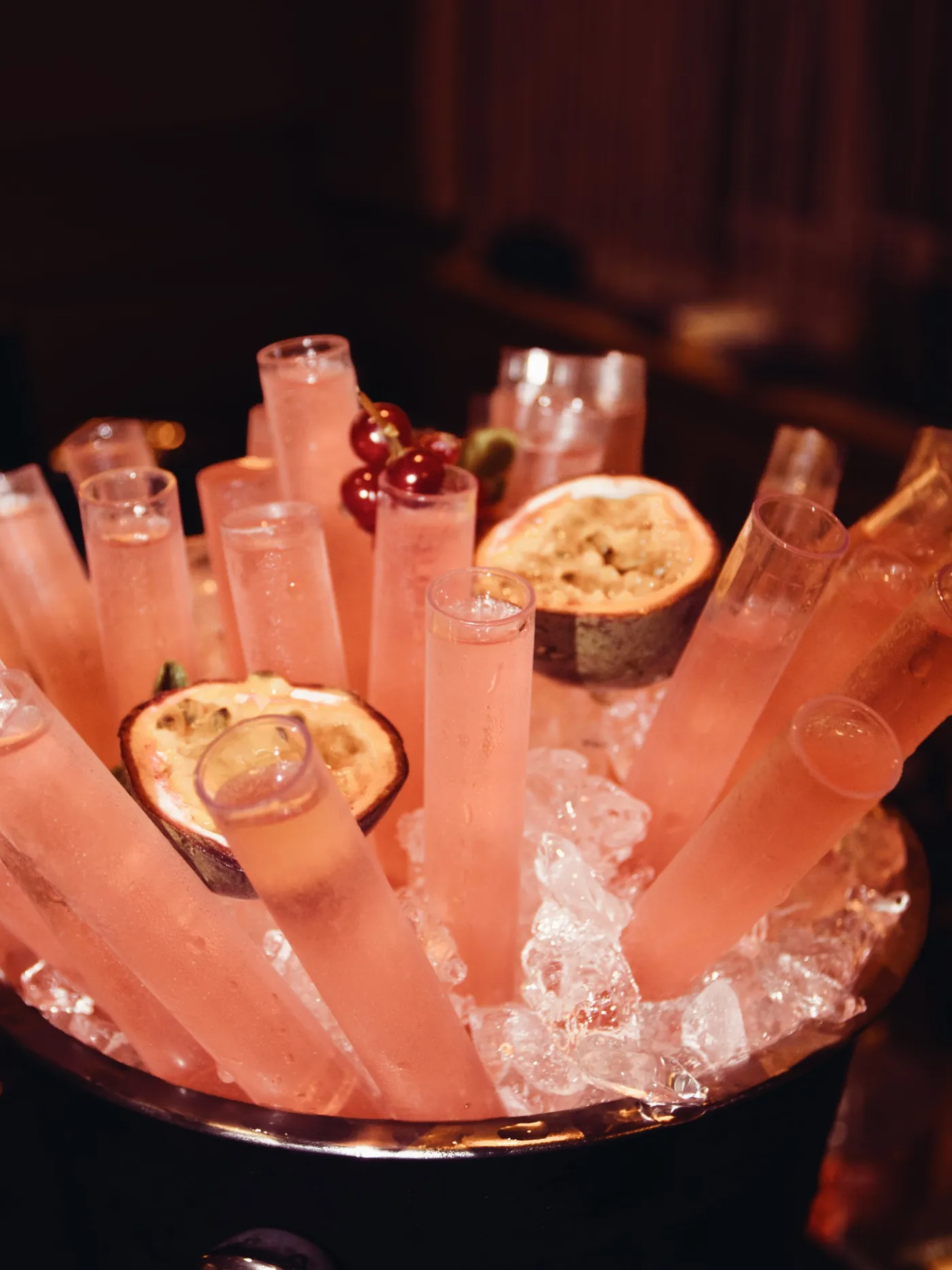 Shots in Reagenzgläsern auf Eis mit Passionsfrucht
